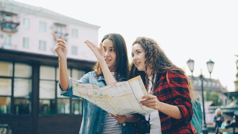 Deux amies consultent une carte dans la rue